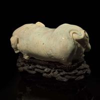 An unusual Chinese elephant-form white-glazed stoneware pillow and carved wood base 白象瓷枕與木座