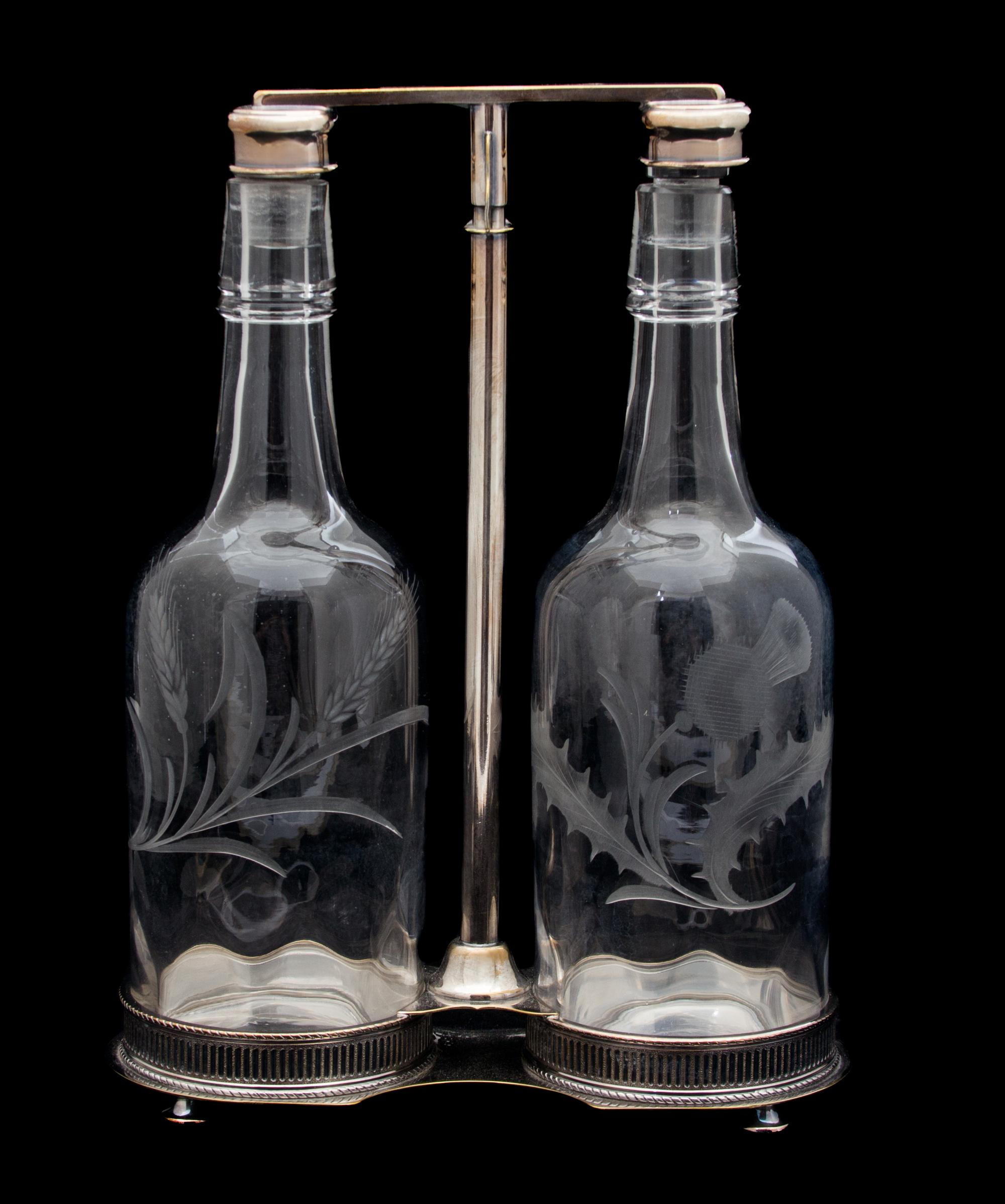 A Scottish Silver Plate Tantalus with Two Thistle Etched Bottles Height overall 12 inches. — 20TH CENTURY