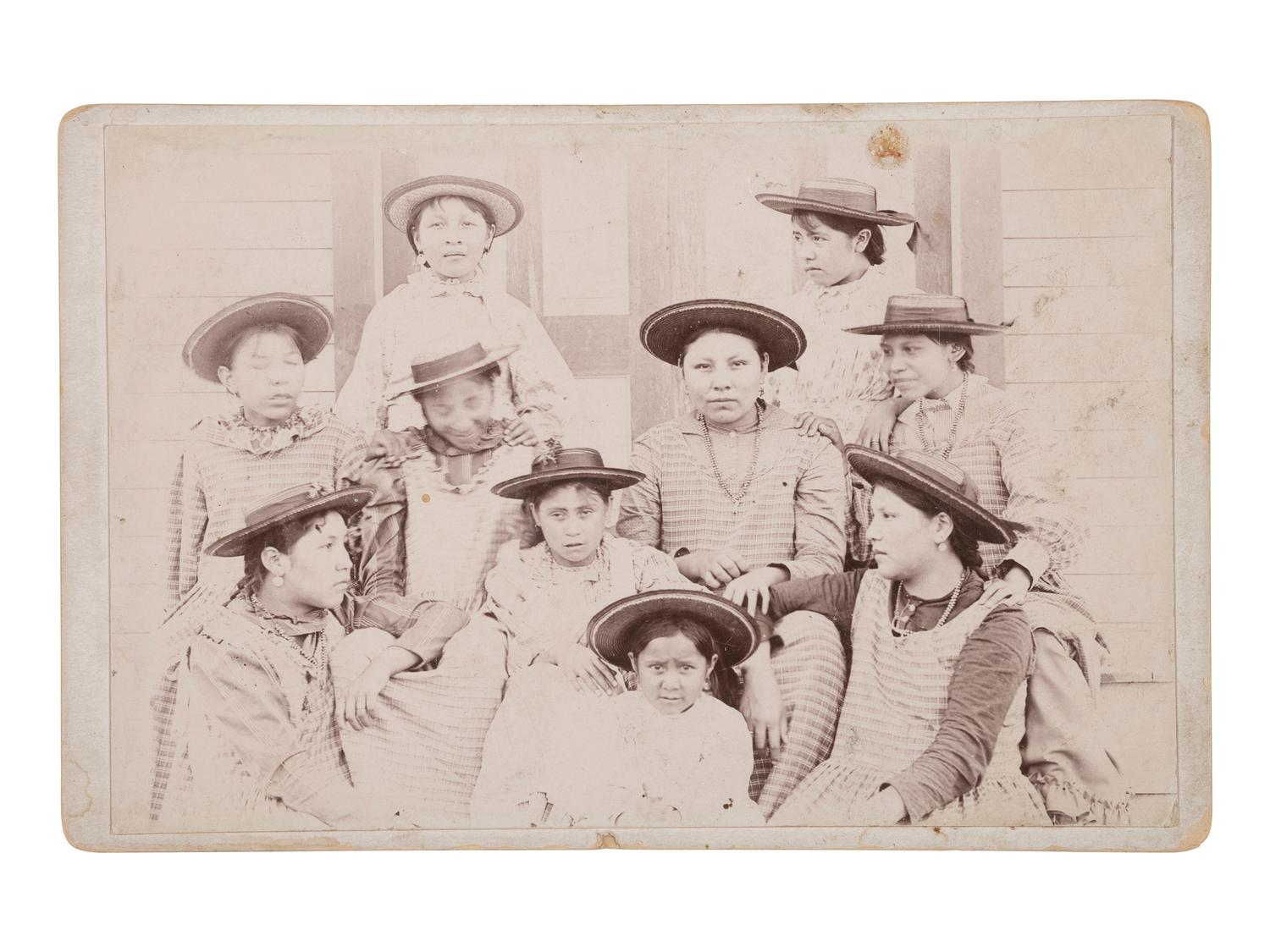 [NATIVE AMERICANS]. Cabinet card of female Indian School students with ledger drawing on verso.