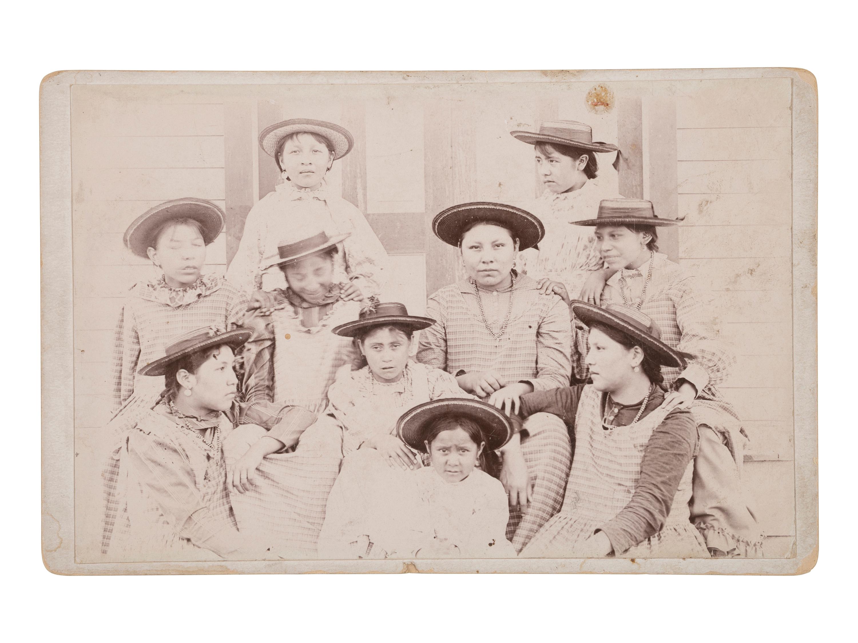 [NATIVE AMERICANS]. Cabinet card of female Indian School students with ledger drawing on verso.