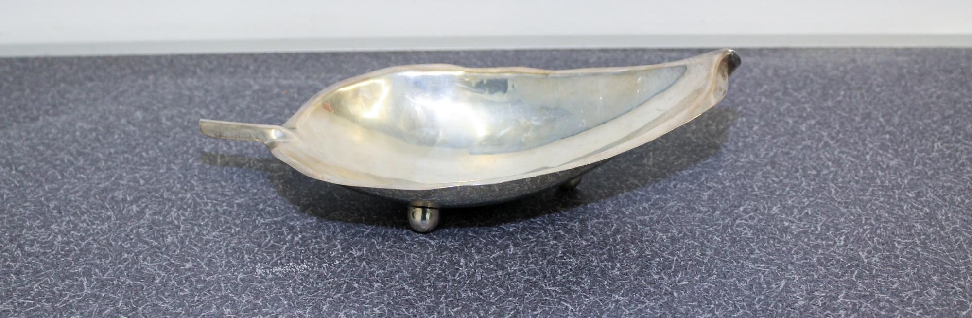 An American Silver Dish, Alfredo Sciarrotta, Providence, RI, modeled in the form of a tobacco leaf and raised on three ball feet.