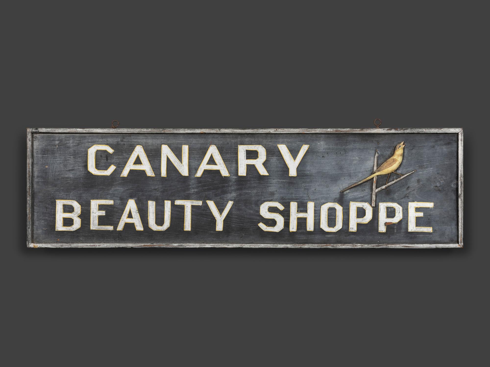A Canary Beauty Shoppe Painted Wood Double-Sided Sign