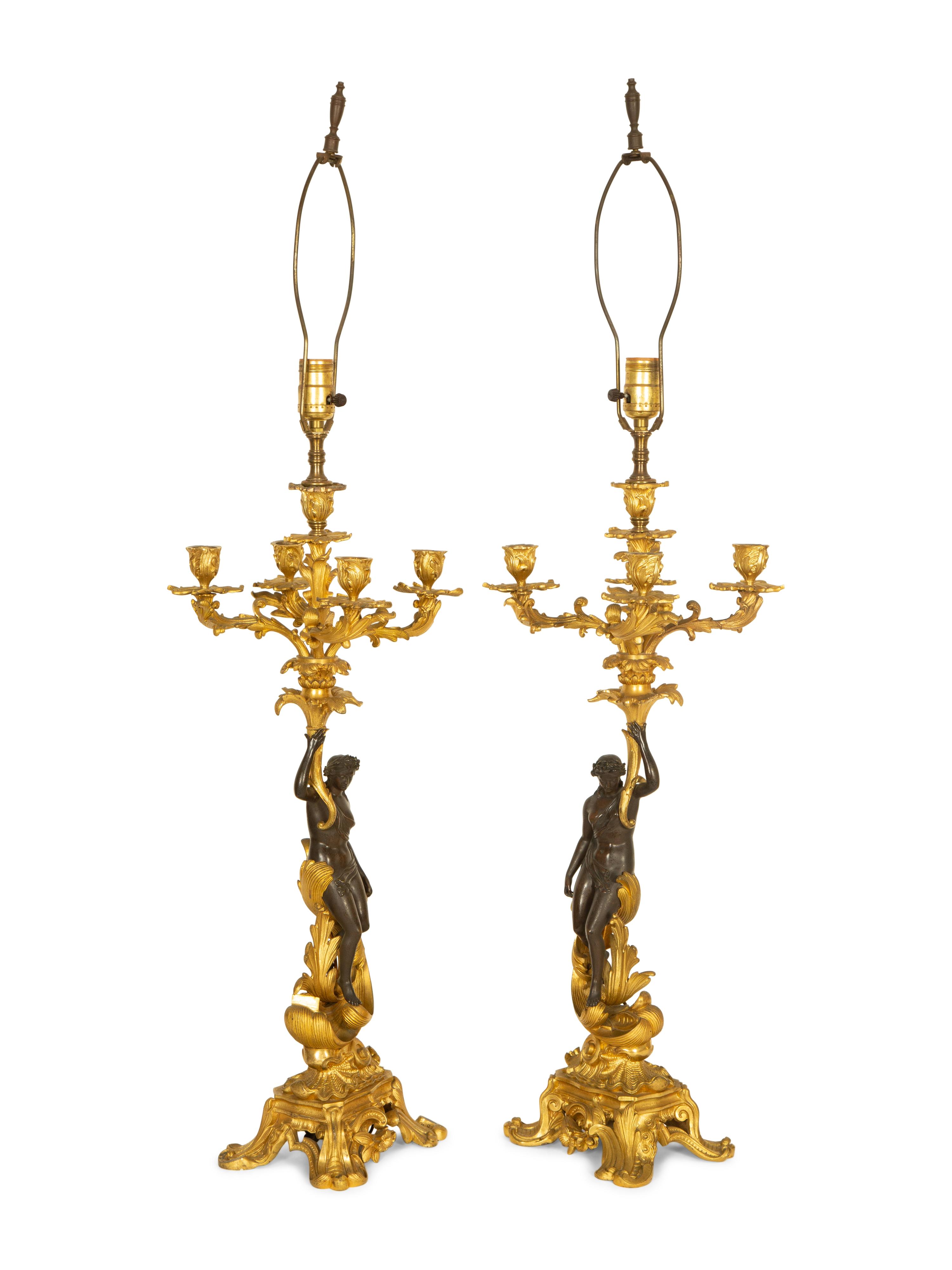 A Pair of Patinated and Gilt Bronze Figural Five-Light Candelabra Mounted as Lamps