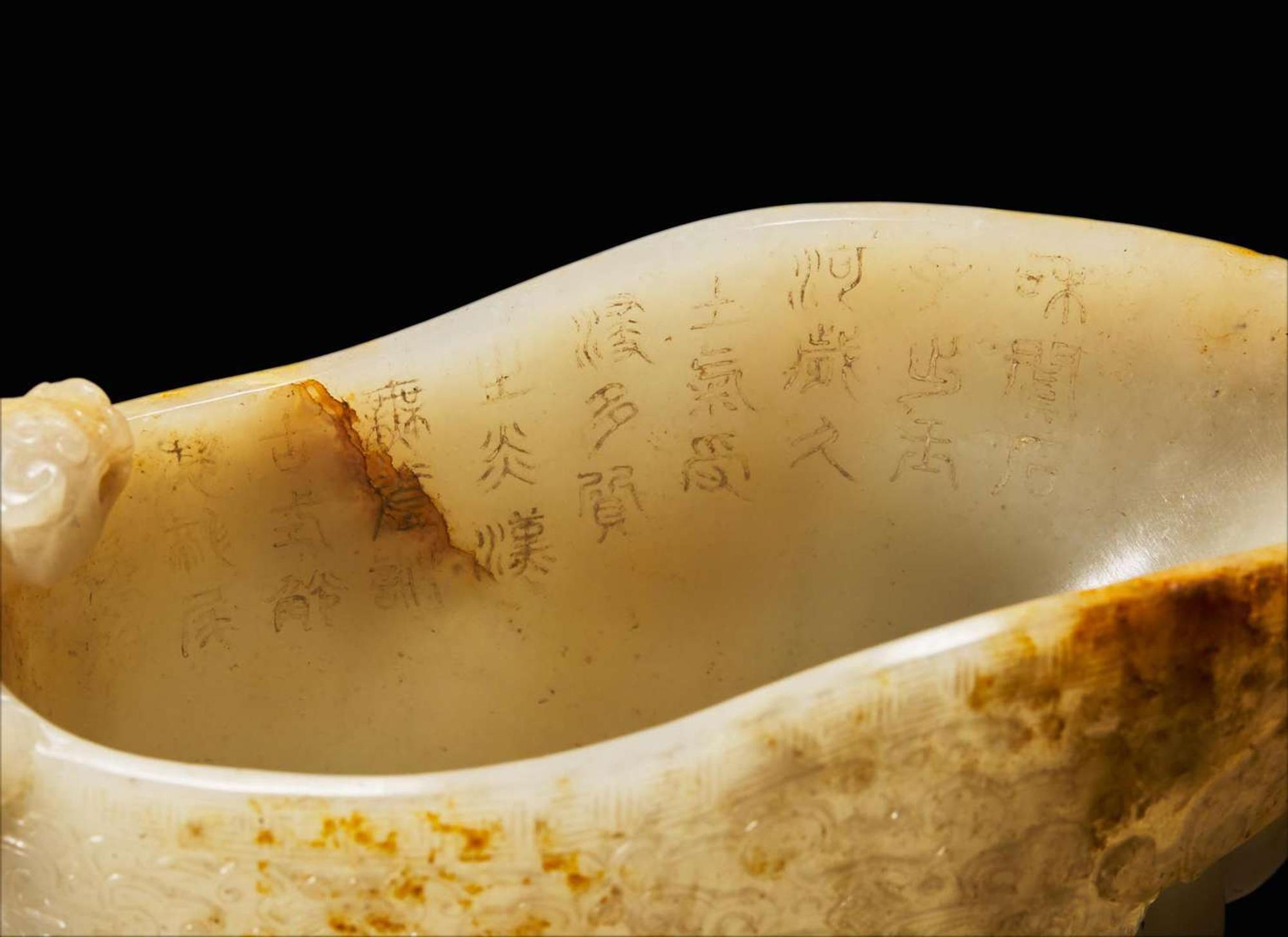A large Chinese carved pale celadon and russet jade rhyton vessel 青白玉雕觥杯