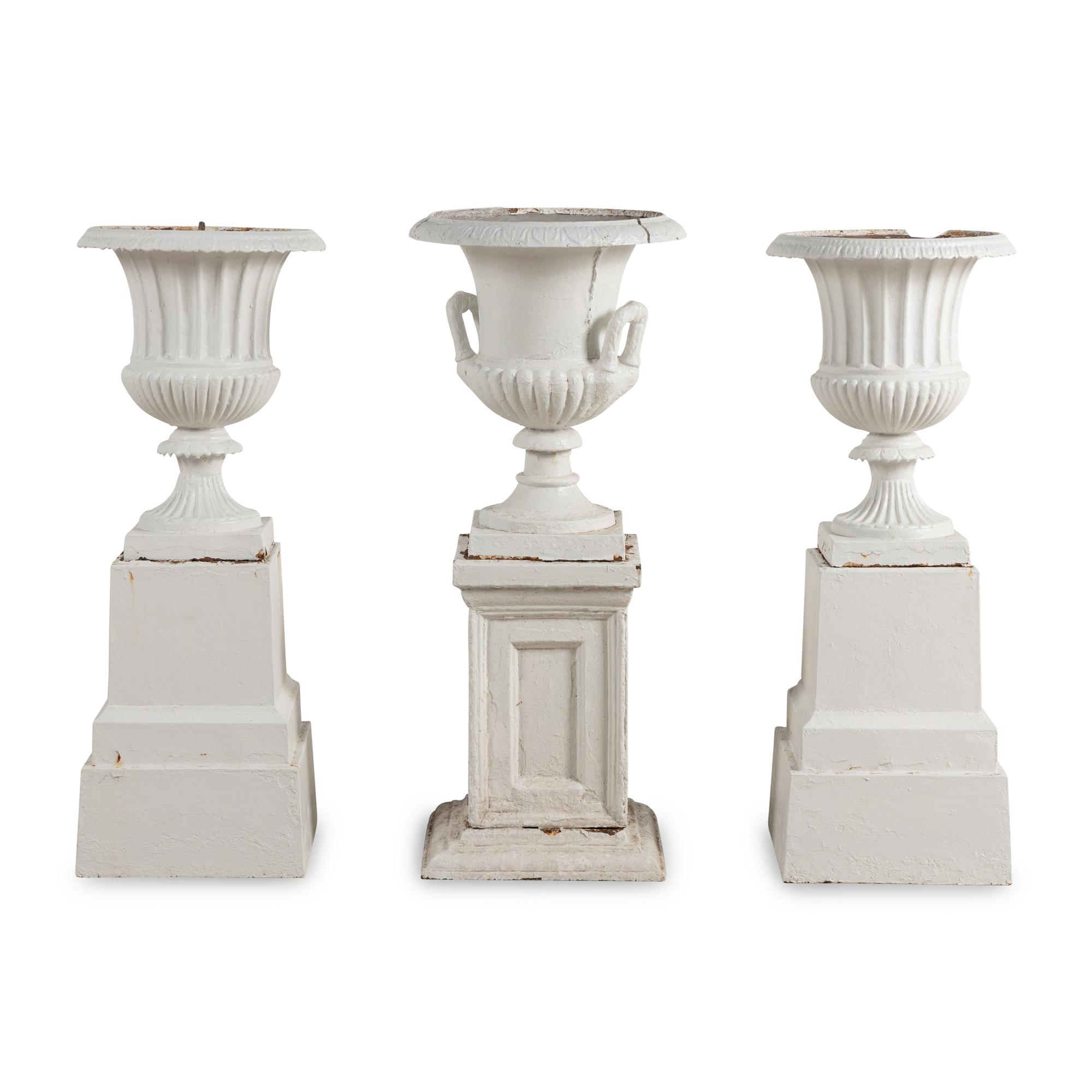 A Set of Three White Painted Iron Garden Urns