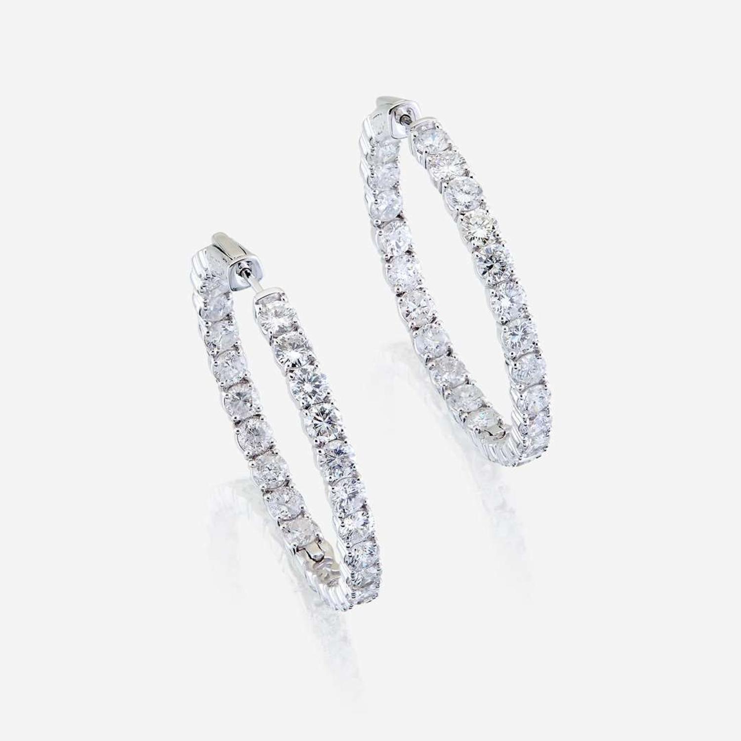 A pair of diamond and fourteen karat white gold earrings