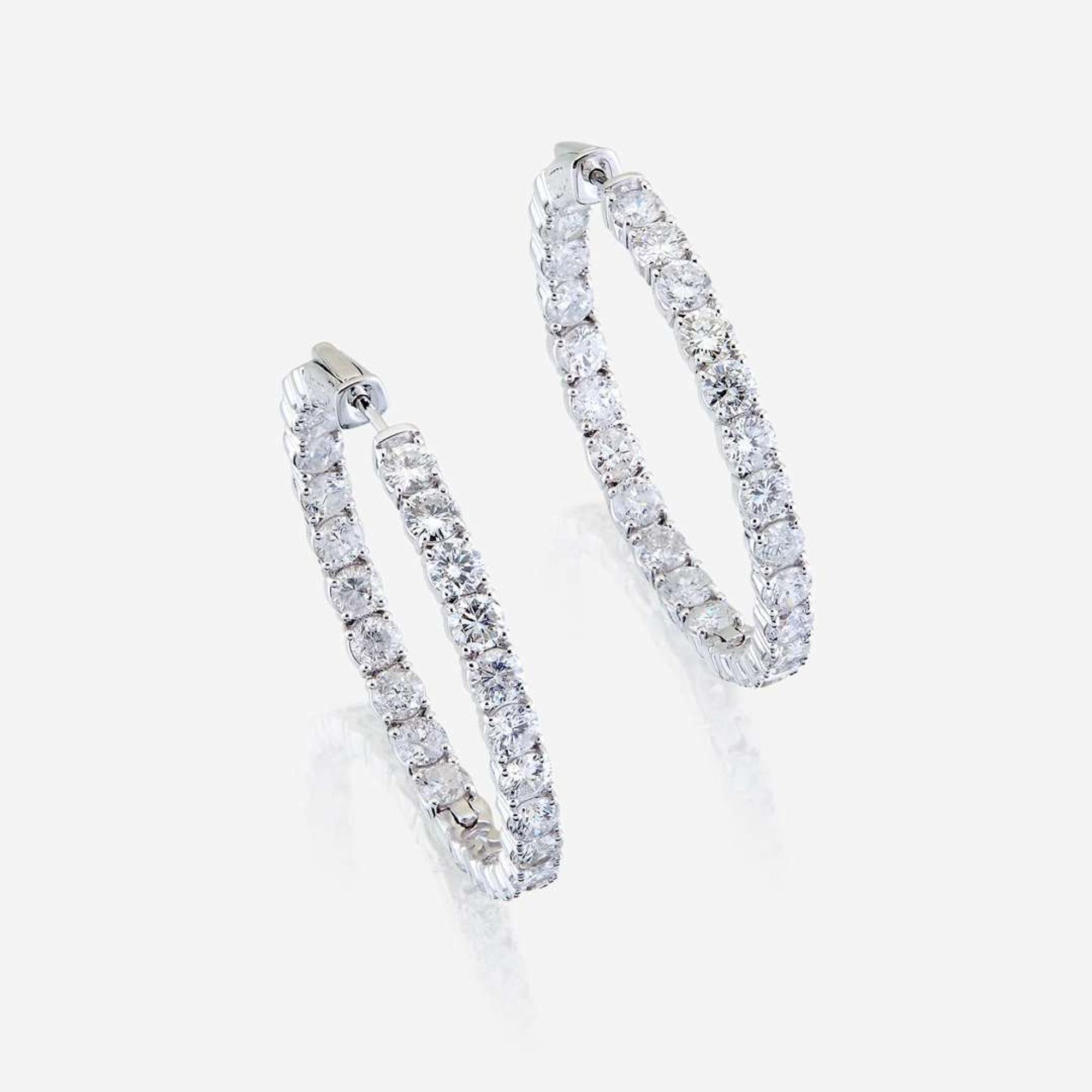 A pair of diamond and fourteen karat white gold earrings