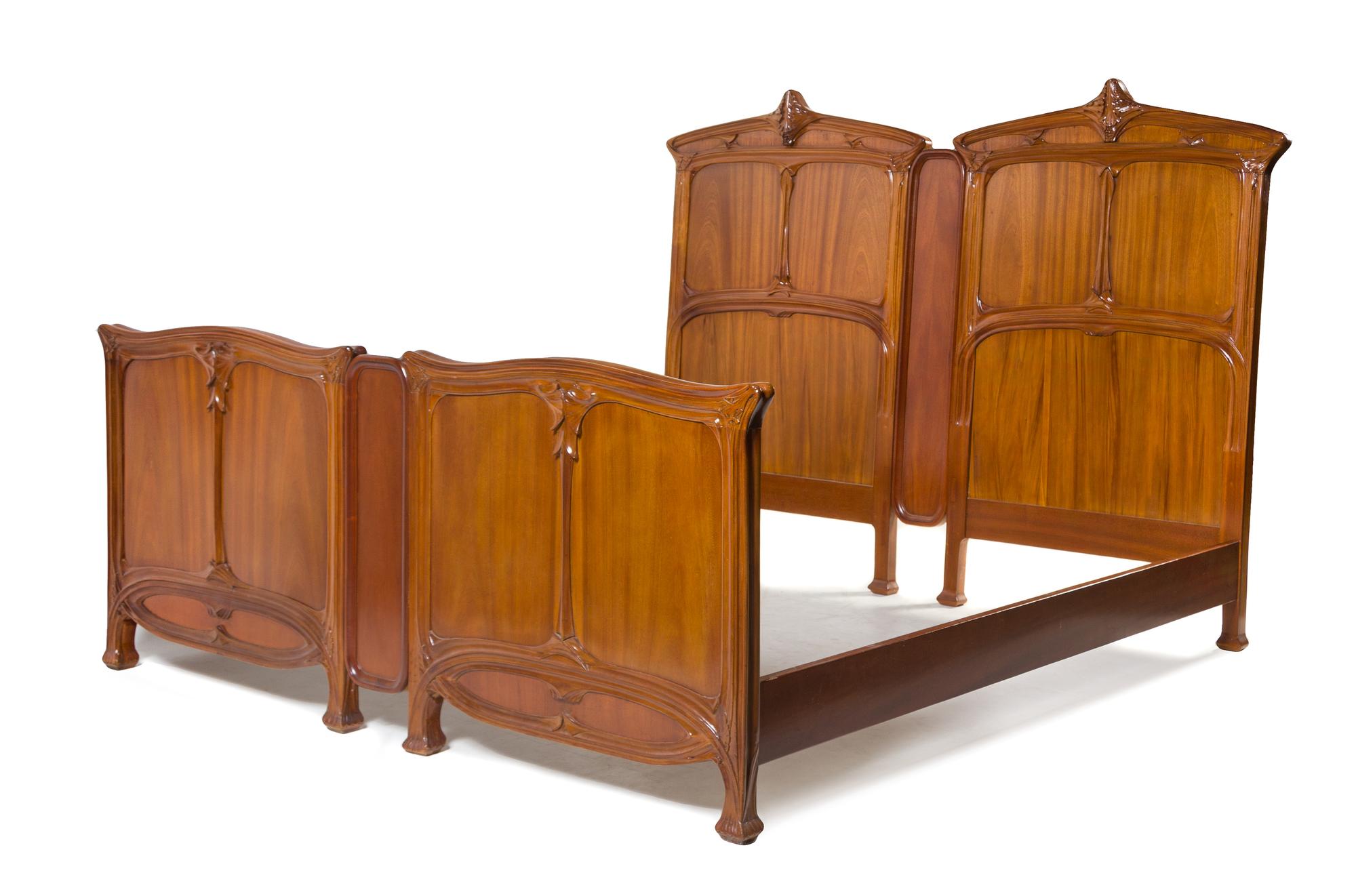Louis Majorelle, (French, 1859-1926), a bedroom set, comprising an armoire separated into two individual display cabinets, two twin hea