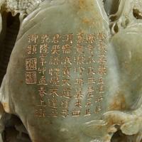 A Large Chinese carved celadon and russet jade mountain and wood stand
