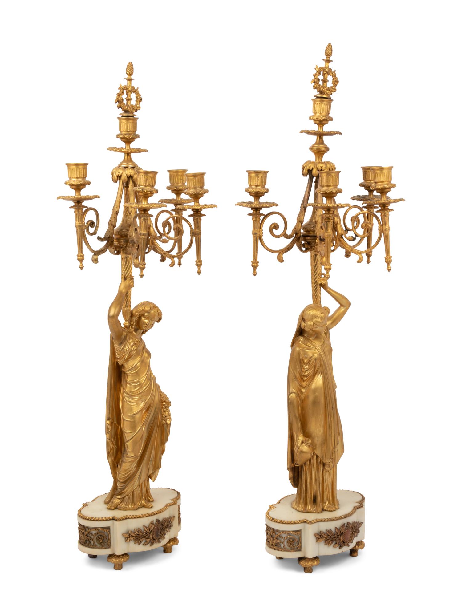 A Louis XVI Style Gilt Bronze and Marble Figural Clock Garniture