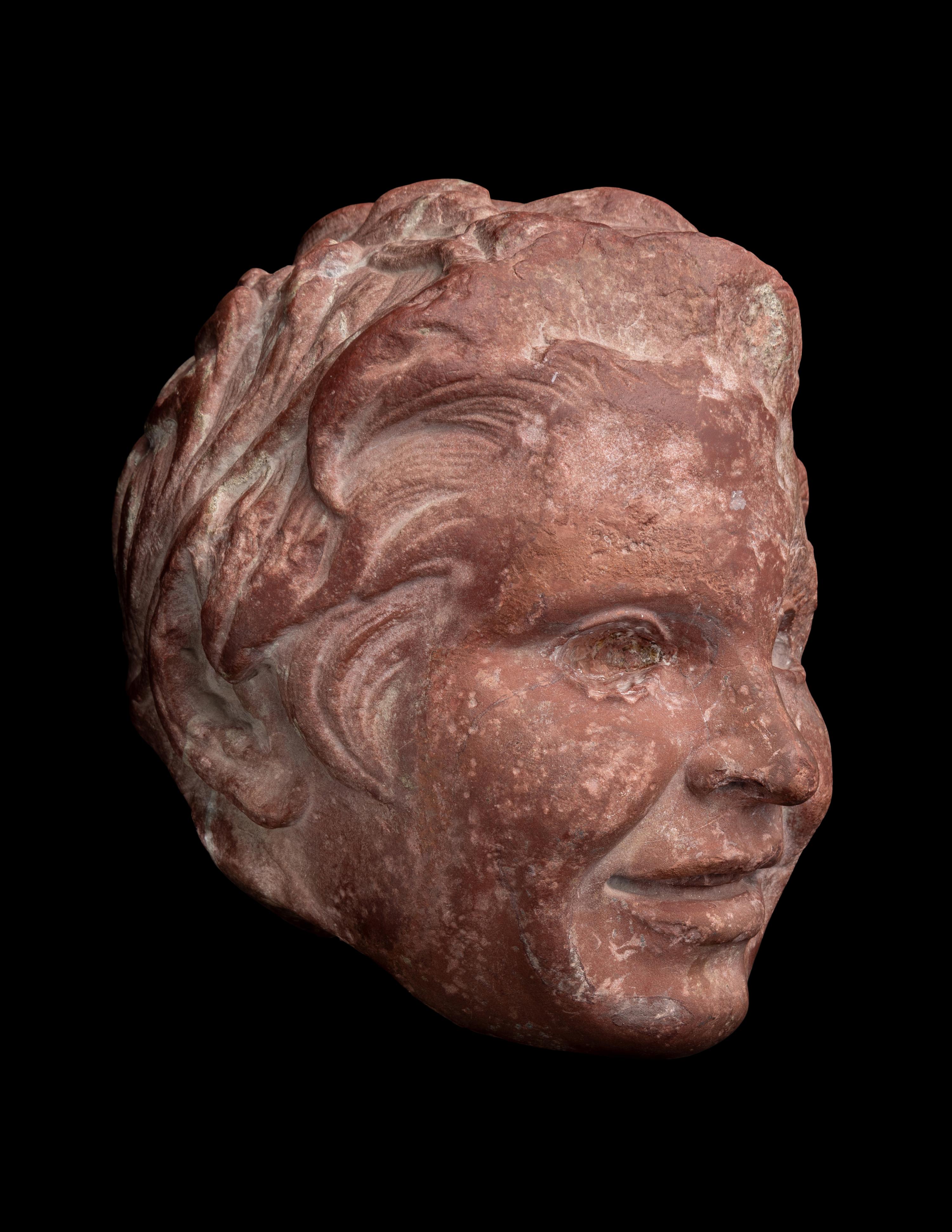 A Roman Rosso Antico Head of a Young Satyr