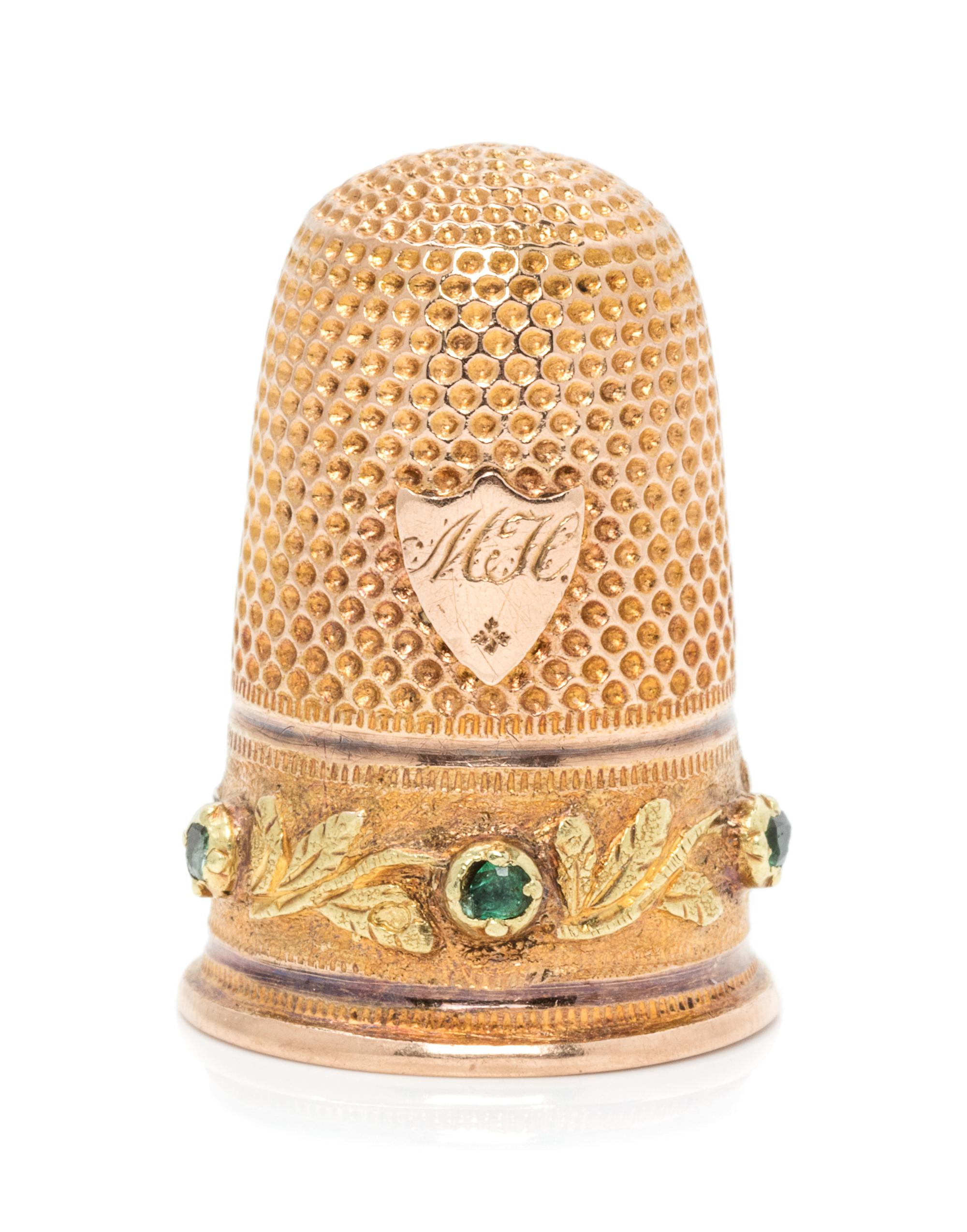 A French 18-Karat Bi-Color Gold and Emerald Thimble, Paris, Late 19th/Early 20th Century, the knurled top and body above the foliate de
