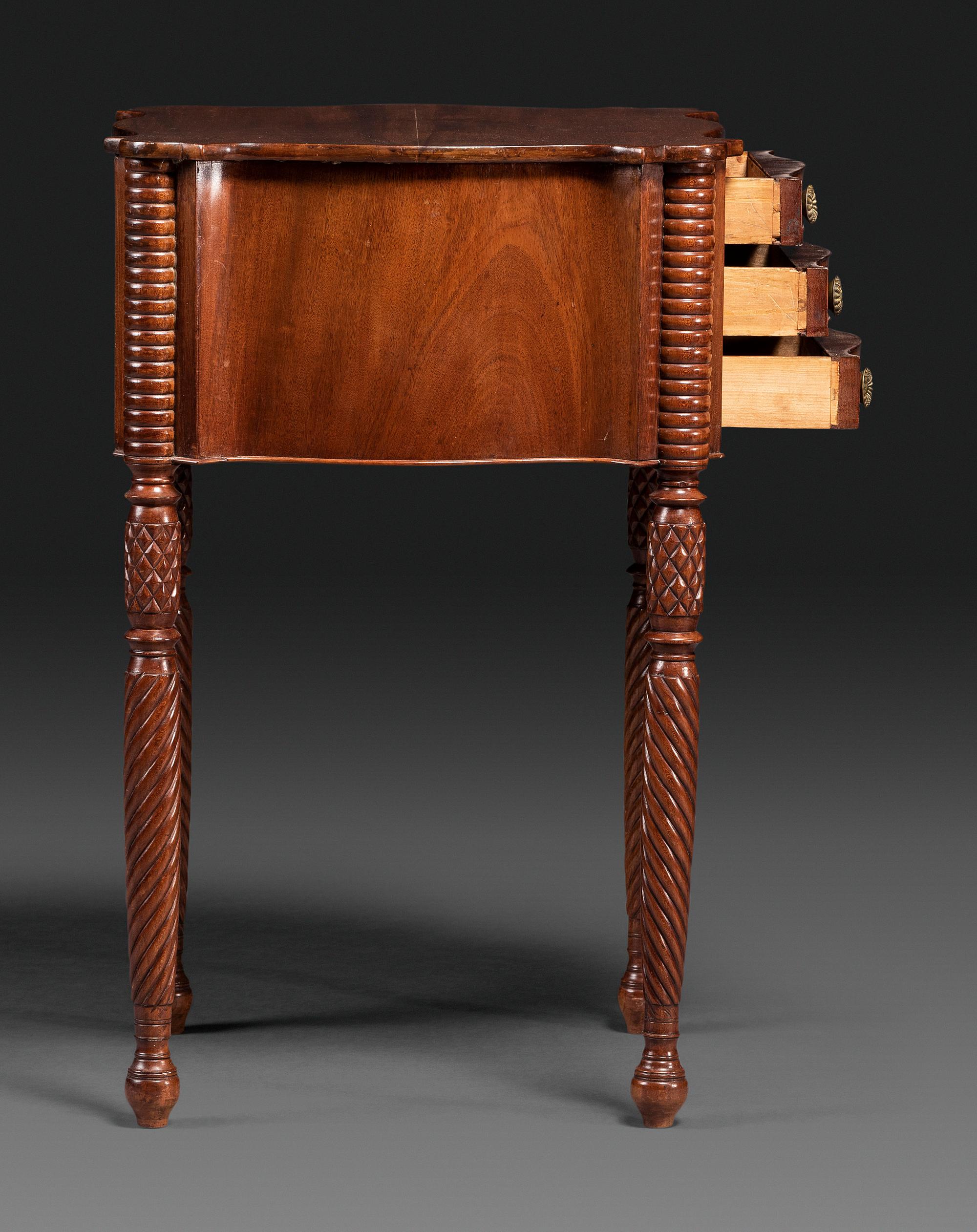A Classical Carved Mahogany Three Drawer Work Table