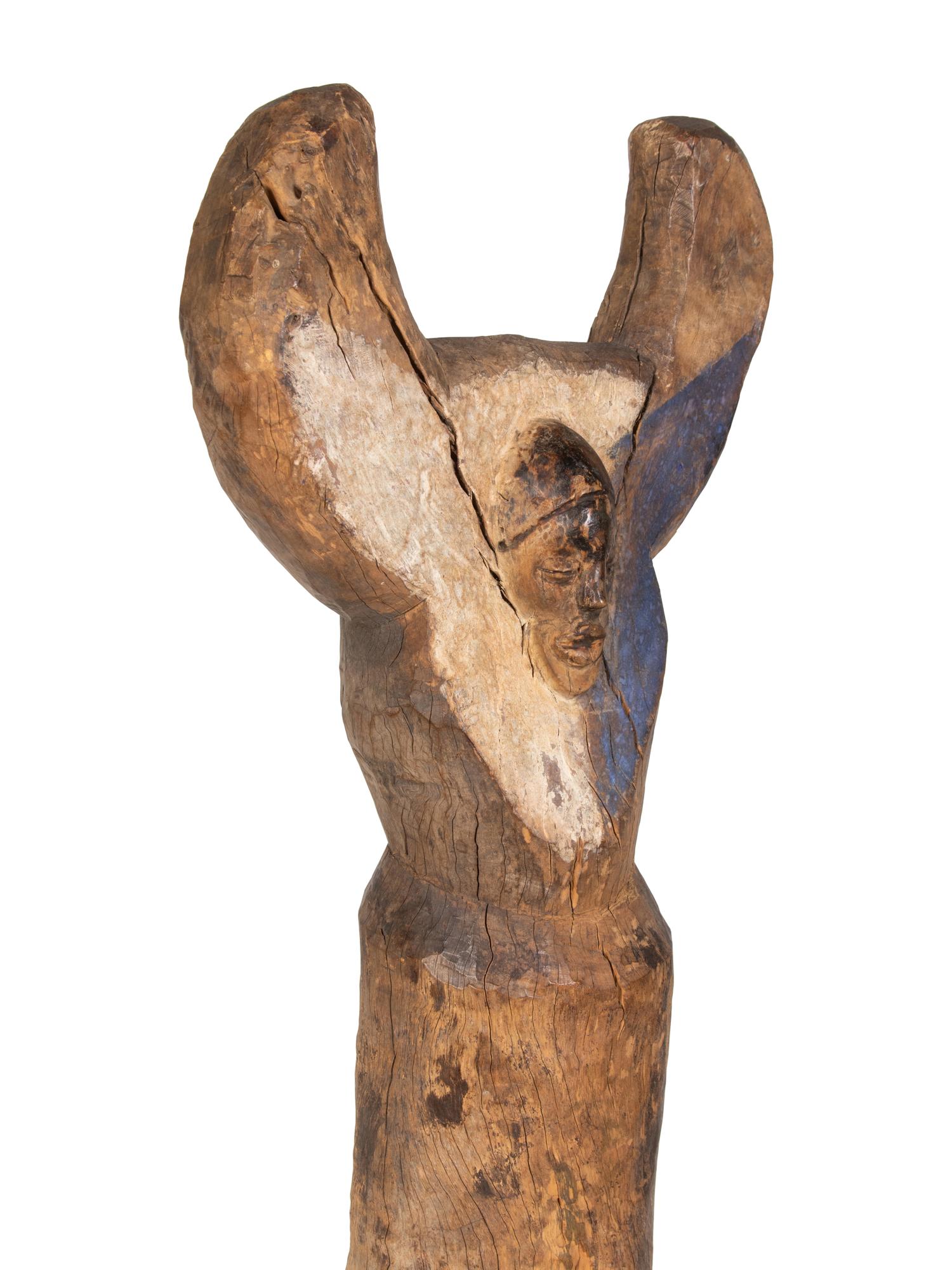 A Yaka Post, with forked finial painted blue and white, a mask in relief at the center