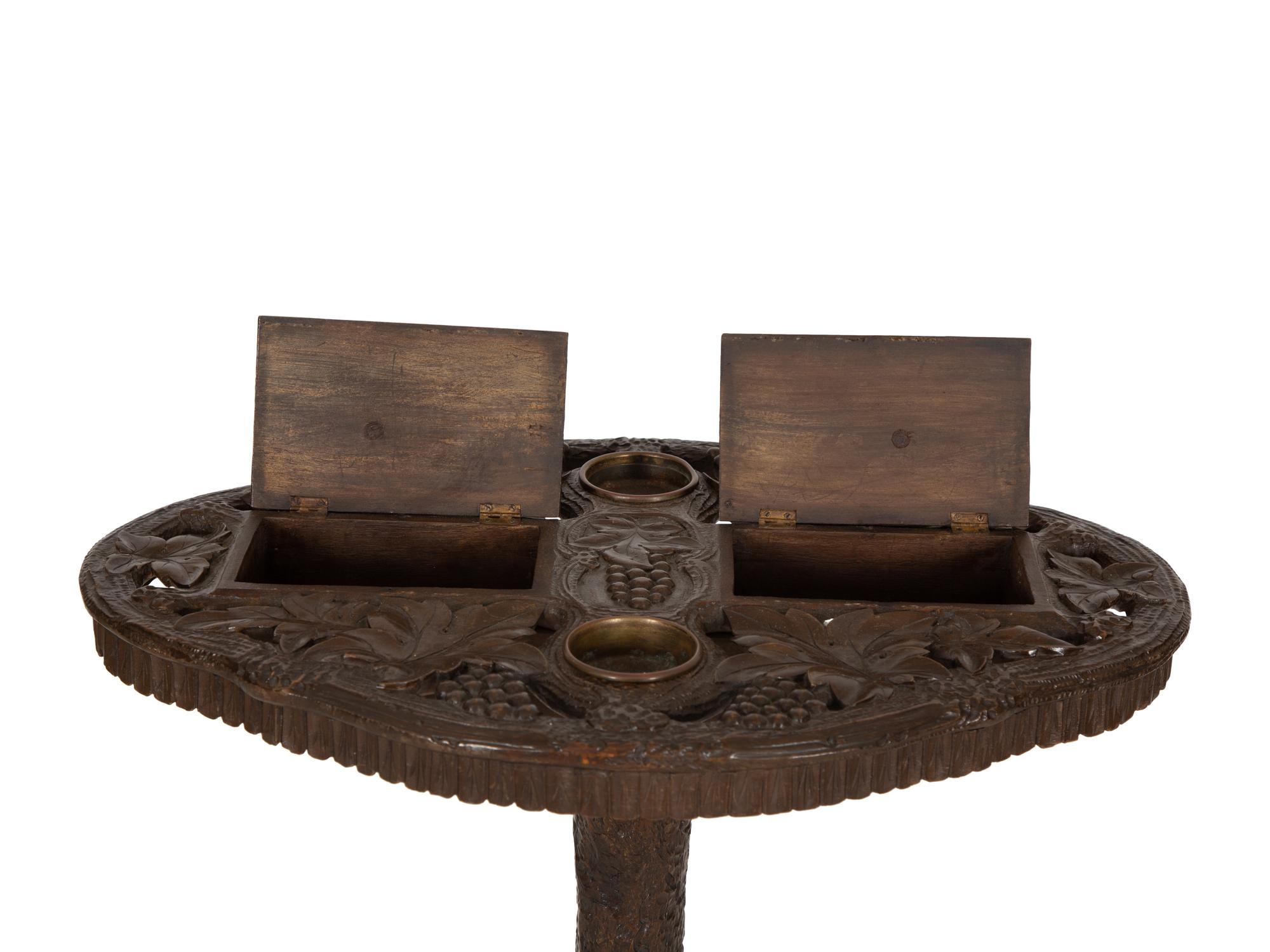 A Swiss Black Forest Carved Wood Smoking Table