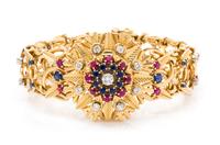 An 18 Karat Yellow Gold Diamond, Ruby and Sapphire Surprise Watch Bracelet, 60.30 dwts.