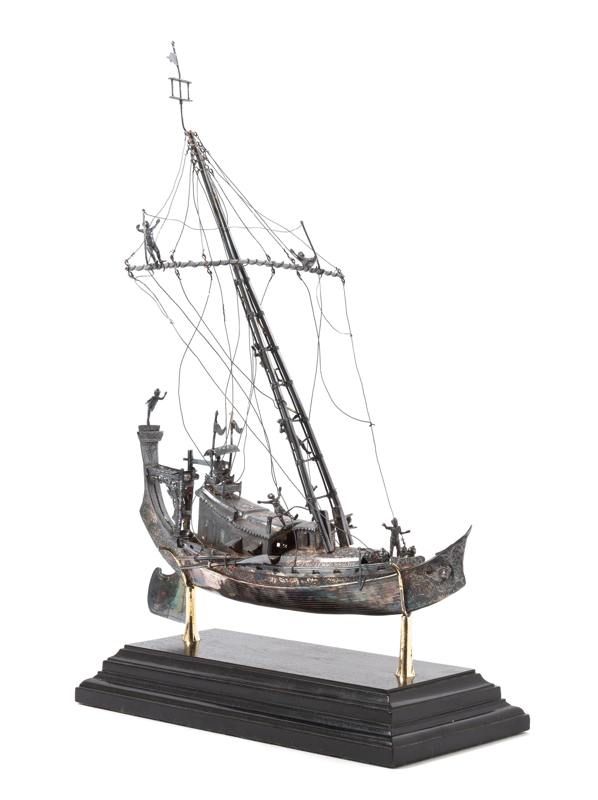 A Silver Model of a Chinese Junk, , applied with figures and realistic riggings, raised on a stepped base.