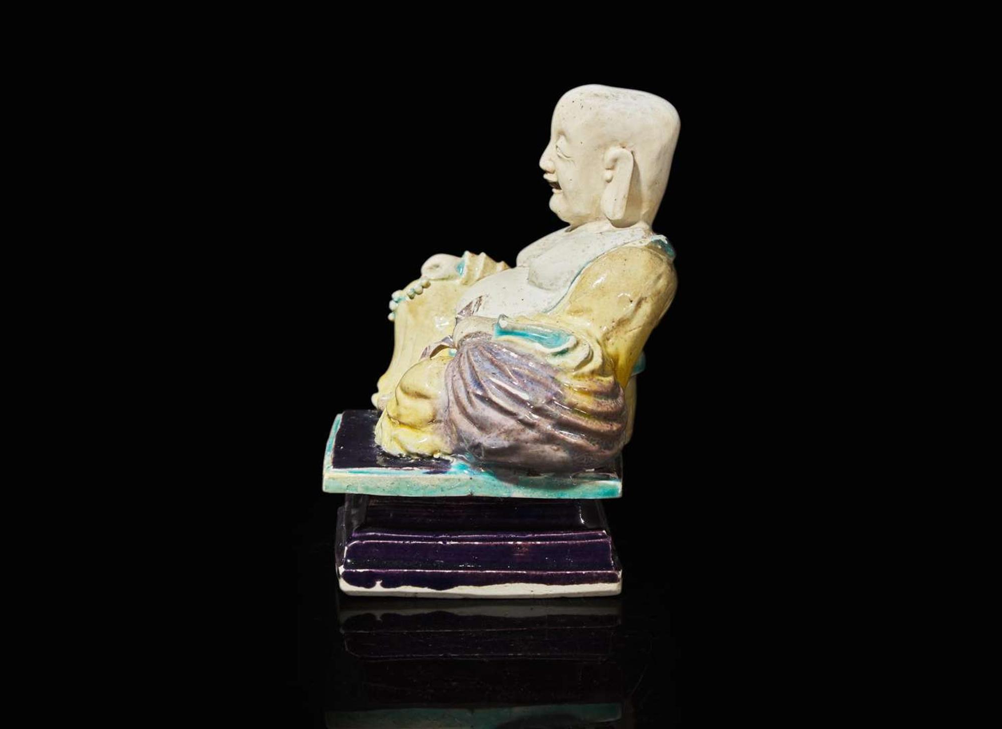 A Chinese glazed biscuit figure of Budai, Kangxi period 素三彩佈袋和尚 清康熙