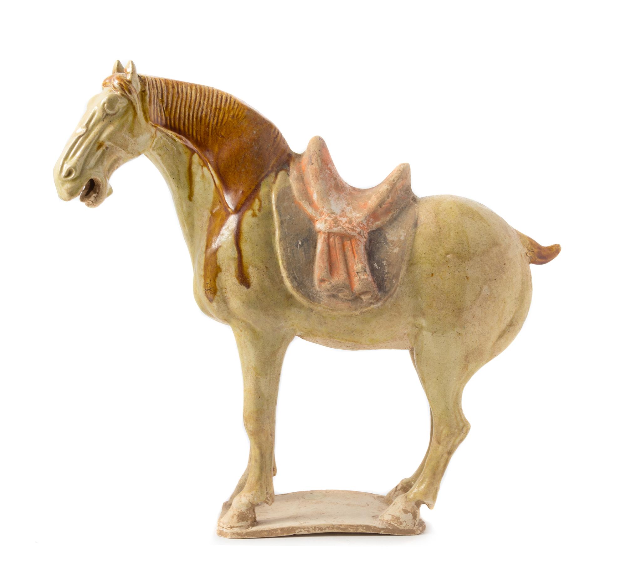 A Straw Glazed Pottery Figure of a Caparisoned Horse TANG DYNASTY Height 12 7/8 inches. — TANG DYNASTY