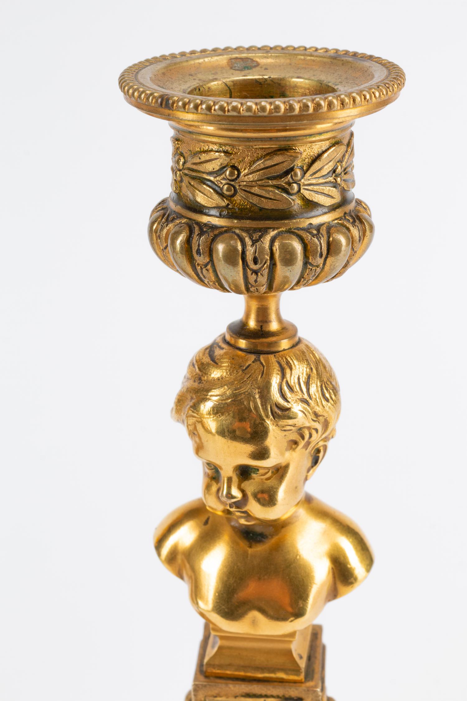 A Pair of Continental Gilt Metal Candlesticks with Busts of Children