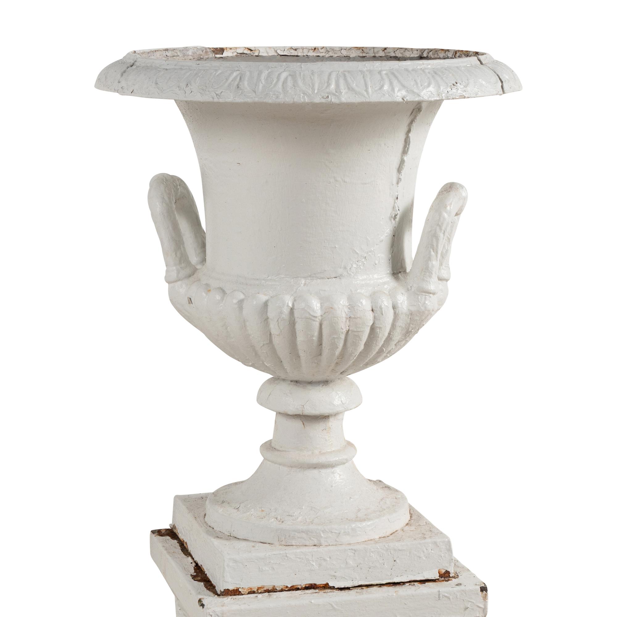 A Set of Three White Painted Iron Garden Urns