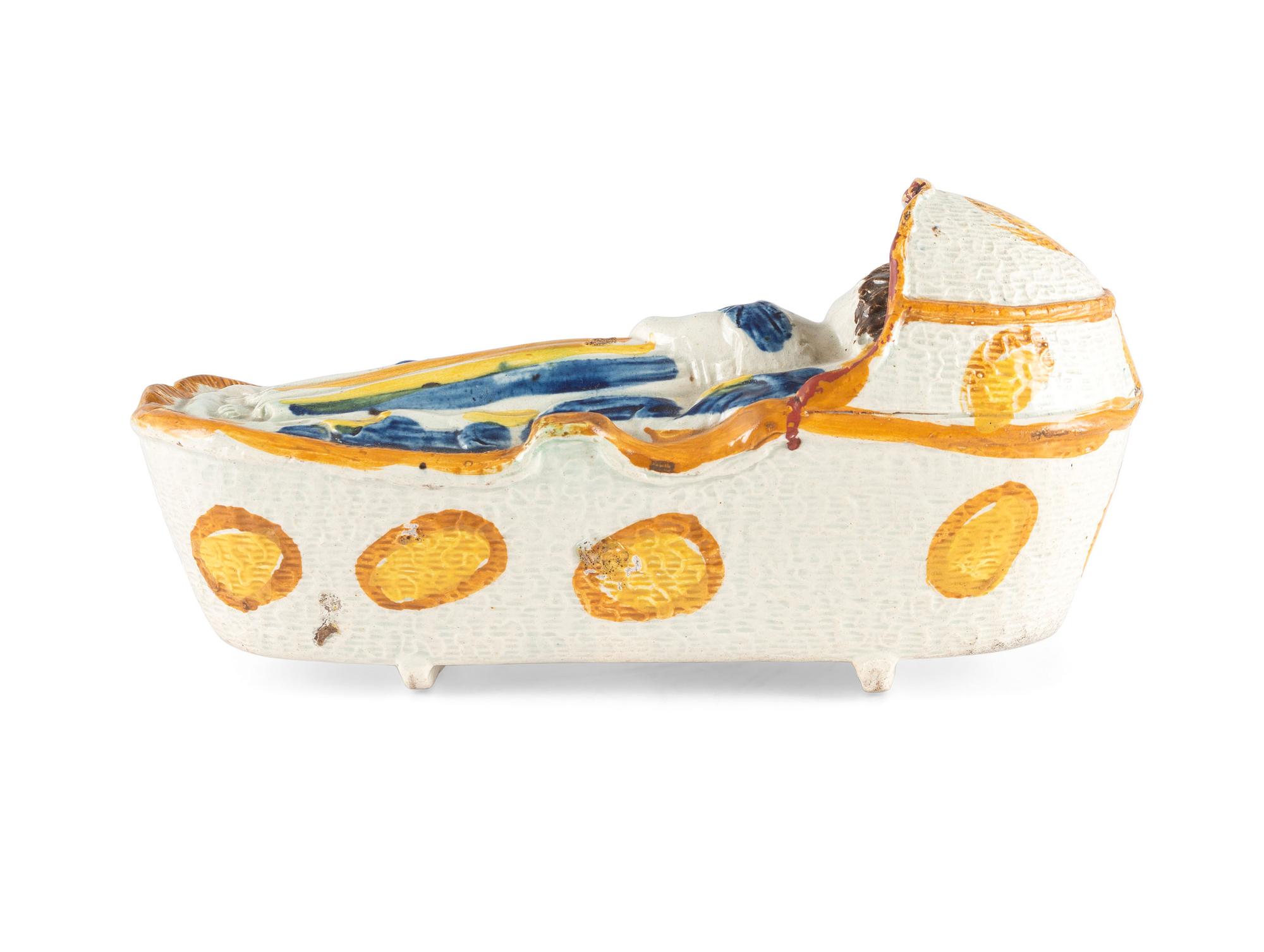 A Staffordshire Pearlware Figure of a Child in a Cradle
