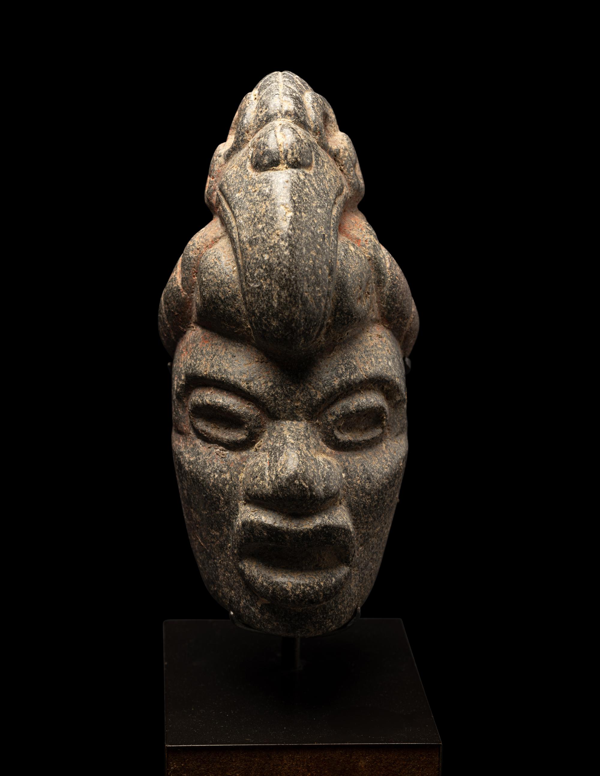A Maya Stone Hacha of a Warrior Wearing a Helmet in the Form of a Macaw