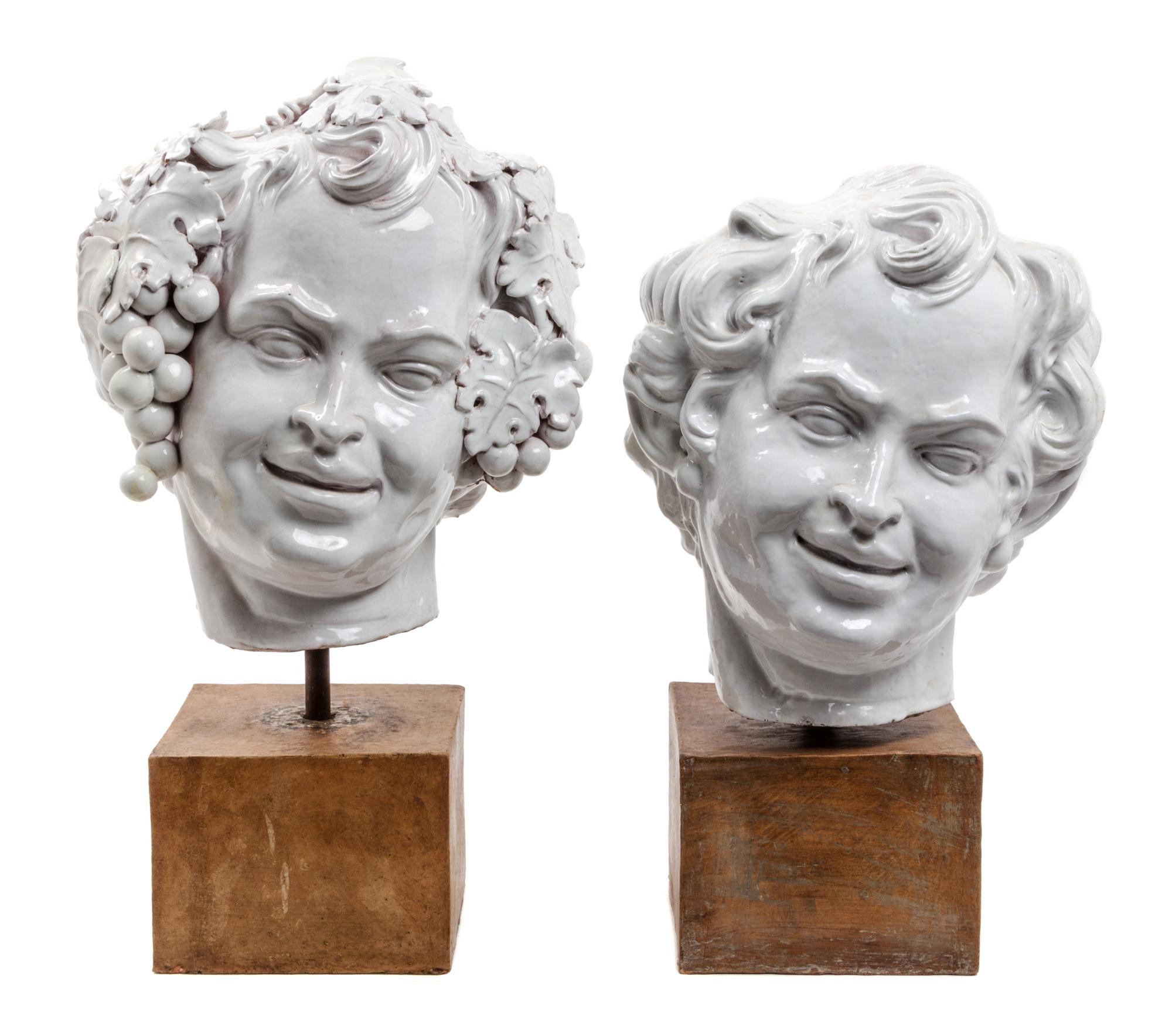 Two White Glazed Terra Cotta Heads of Bacchus Height of first 16 1/2 inches.