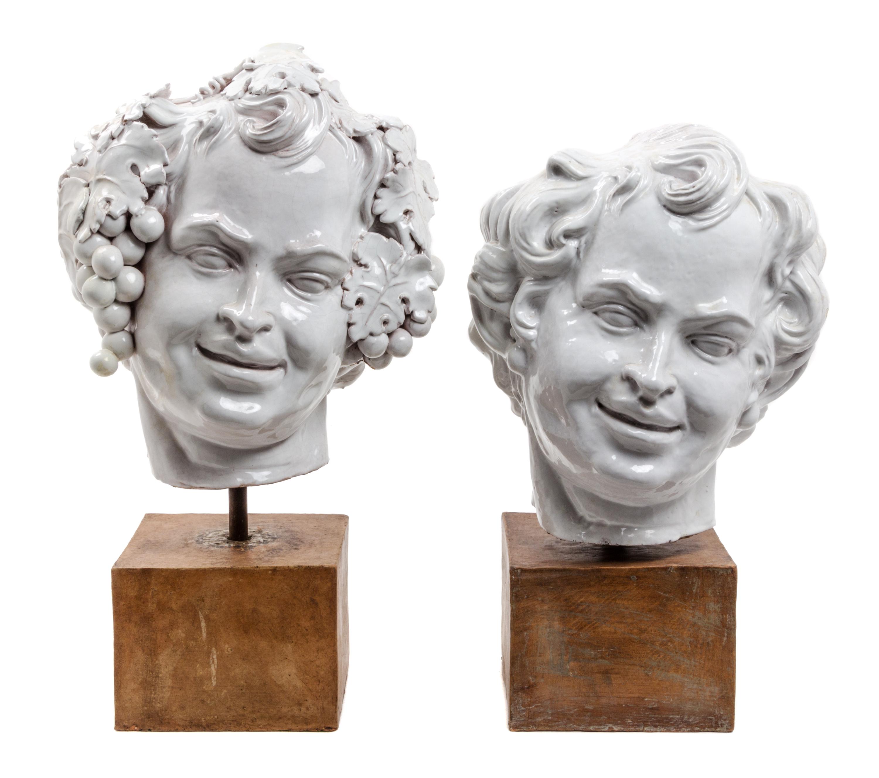 Two White Glazed Terra Cotta Heads of Bacchus Height of first 16 1/2 inches.