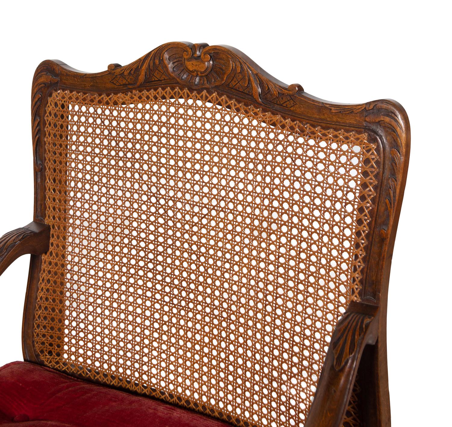 A Pair of Régence Style Carved Walnut and Caned Fauteuils à la Reine
