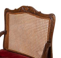 A Pair of Régence Style Carved Walnut and Caned Fauteuils à la Reine