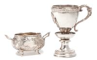 Two German Silver Table Articles, , the first a handled cup raised on pedestal, having a foliate border and vacant emblematic crest, ma