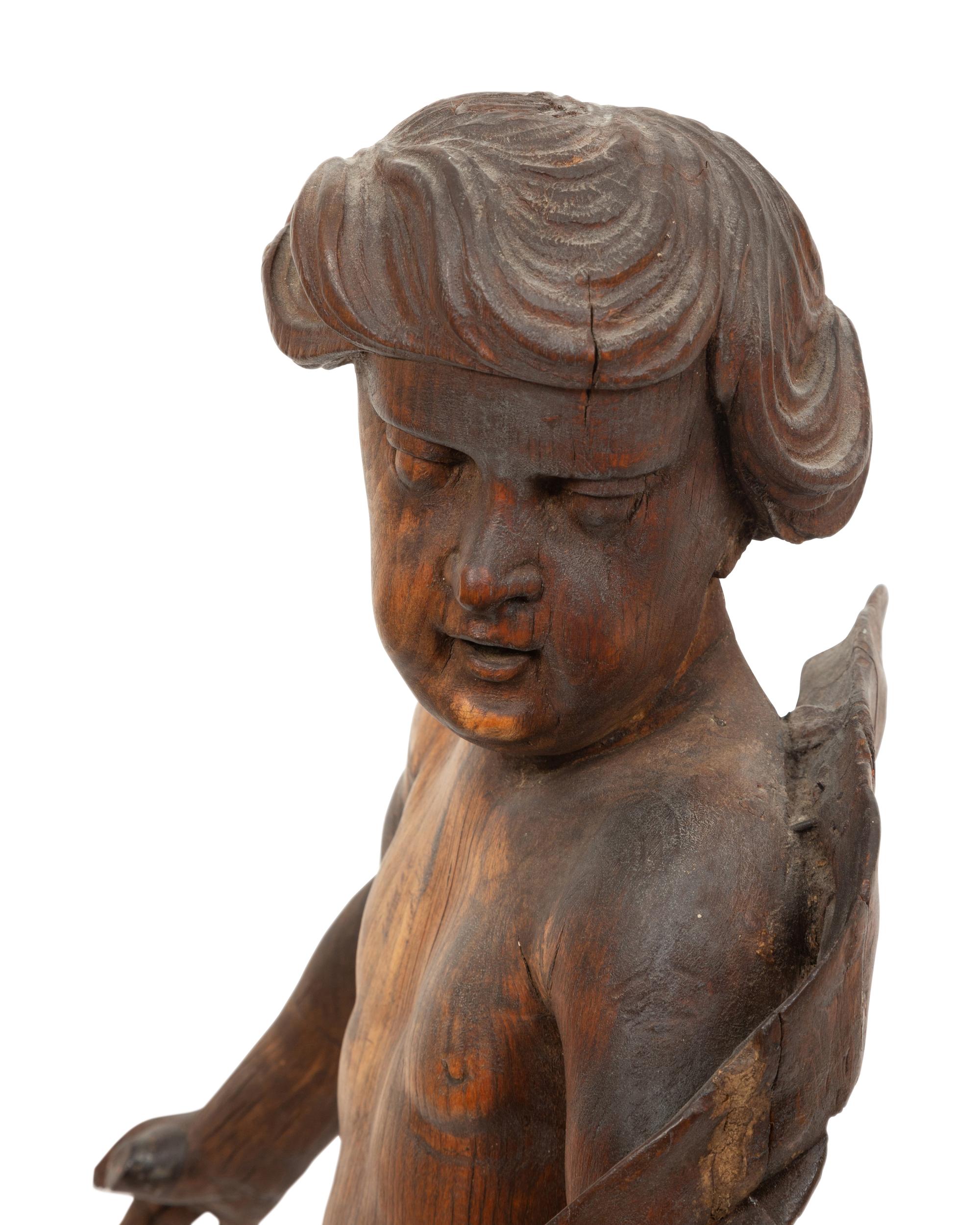 An Italian Carved Walnut Figure of Putto