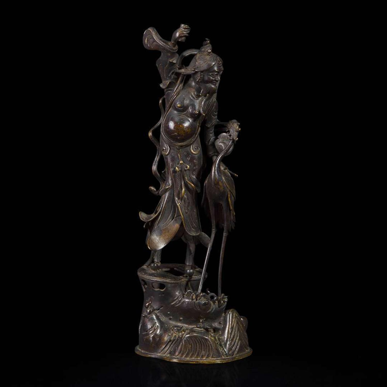 A patinated bronze figure of a Daoist immortal with crane 道教仙人与鹤铜塑 17th century ????