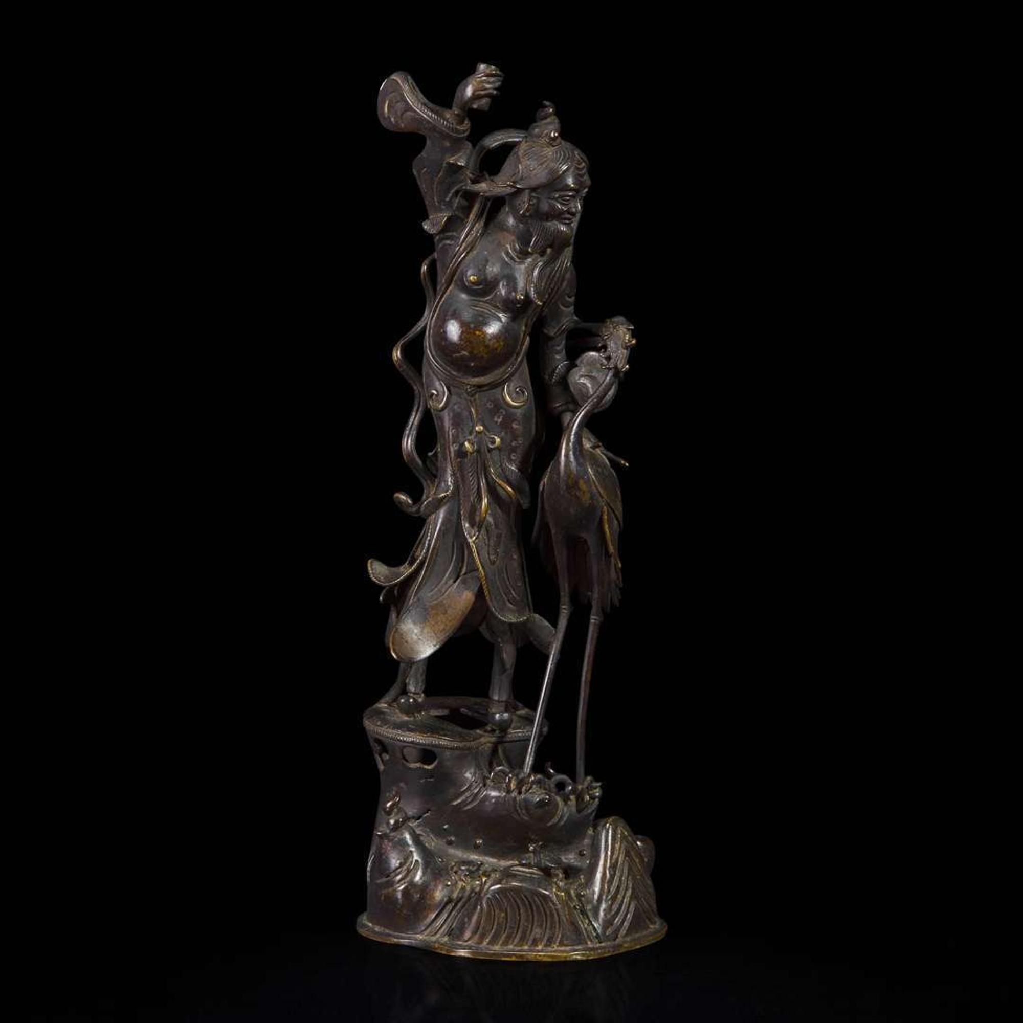 A patinated bronze figure of a Daoist immortal with crane 道教仙人与鹤铜塑 17th century ????