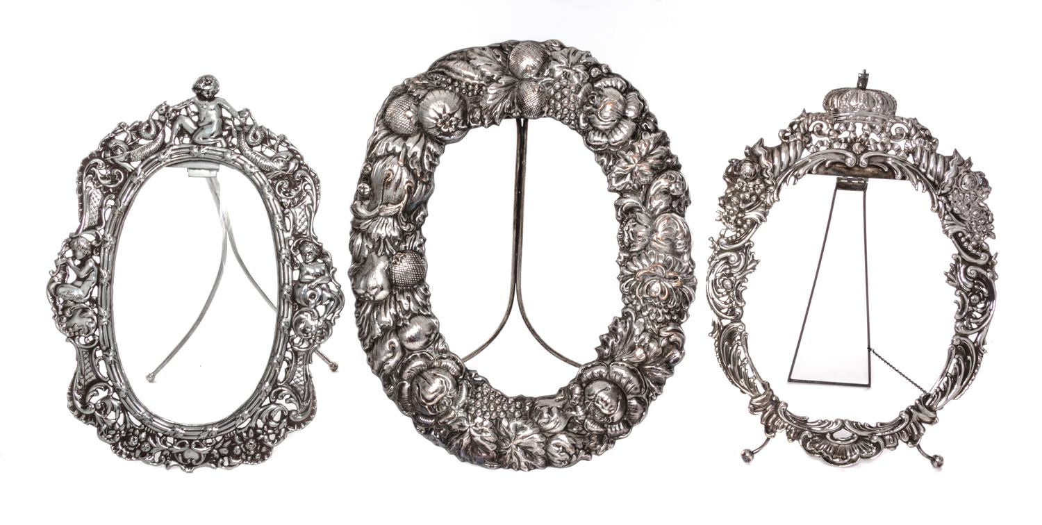 Three Silver-Plate Picture Frames, , each oval, one with a repousse border showing fruit and flowers, one with a crowned border chased