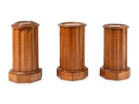A Set of Three Continental Satin Birch Marble-Top Pedestal Cabinets