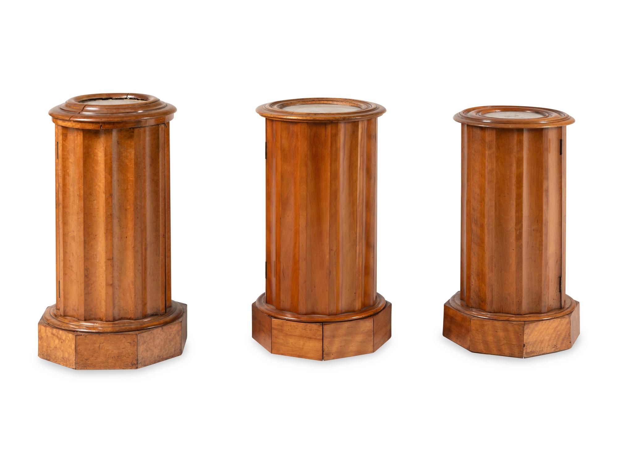 A Set of Three Continental Satin Birch Marble-Top Pedestal Cabinets