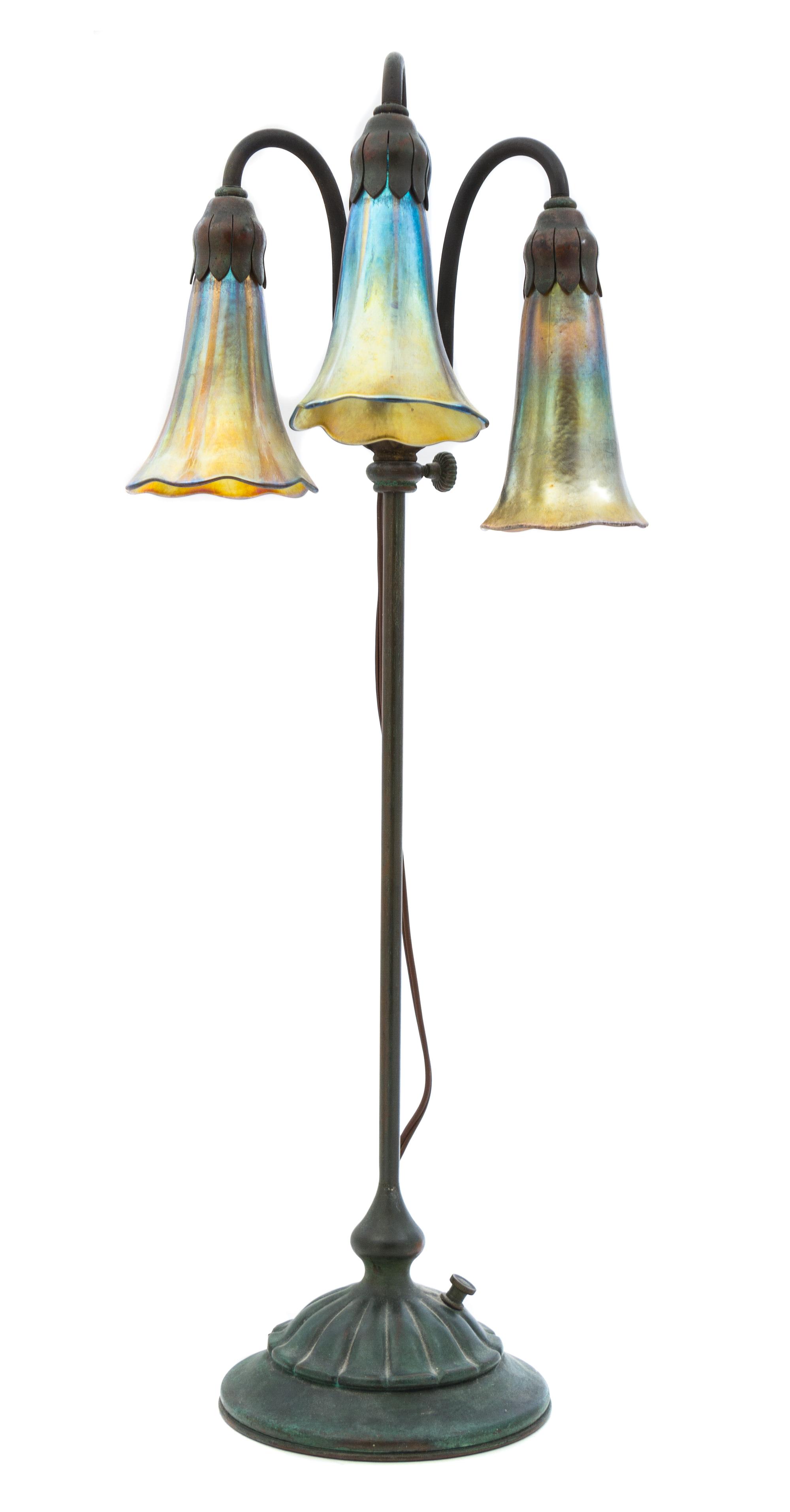 A Tiffany Studios Bronze and Favrile Glass Three-Light Lily Lamp Height 22 1/2 inches.