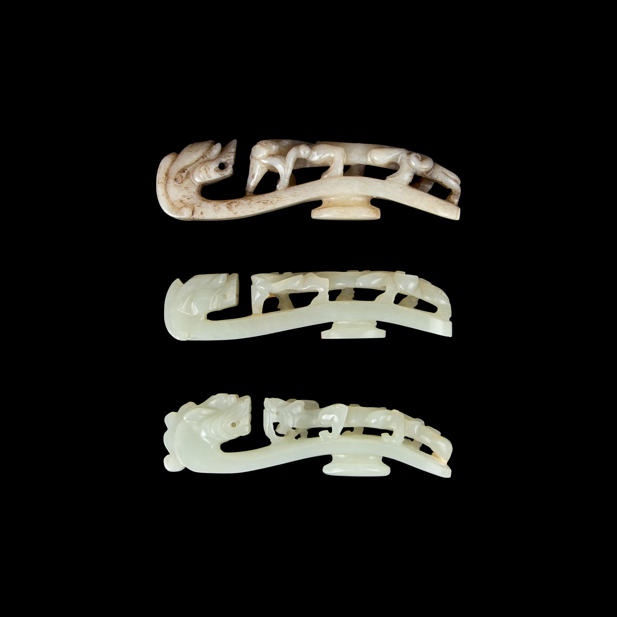 A Chinese 'Chicken-Bone' Jade and Two Pale Celadon Jade 'Dragon' Belt Hooks, Qing Dynasty 清 玉龍鉤三件