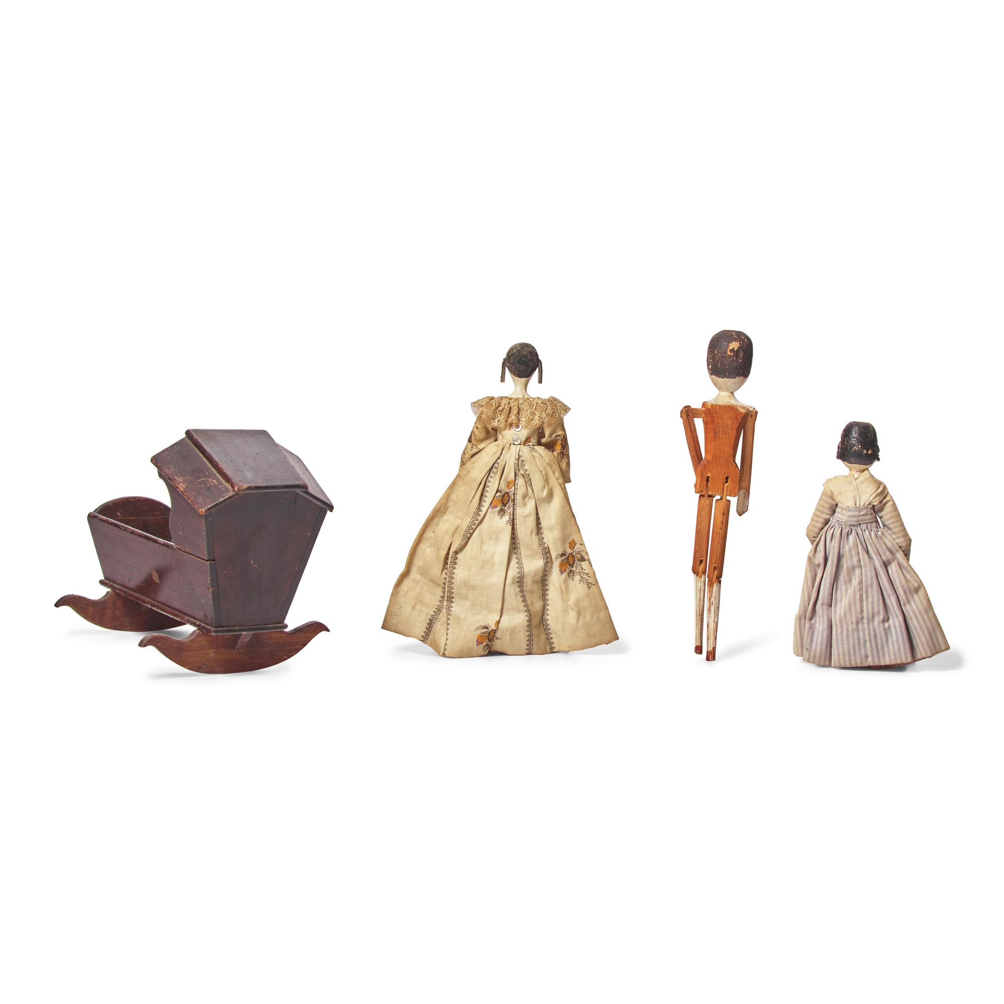 A Group of Three Peg Wooden Dolls and a Miniature Wood Cradle