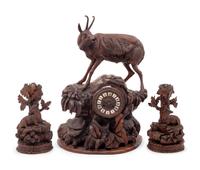 A Black Forest Carved Clock Garniture
