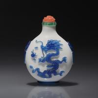 A Chinese Glass Overlay "Dragons" Snuff Bottle, Qing Dynasty, 18th/First Half 19th century — 清中期 涅白地套藍料雙龍戲珠紋鋪首啣環耳鼻煙壺