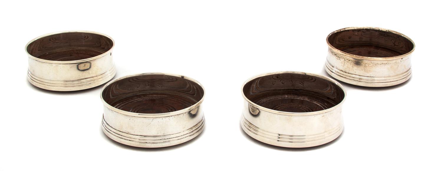 Four English Silver Bottle Coasters, Broadway & Co., Birmingham, 1982, having treen bottoms