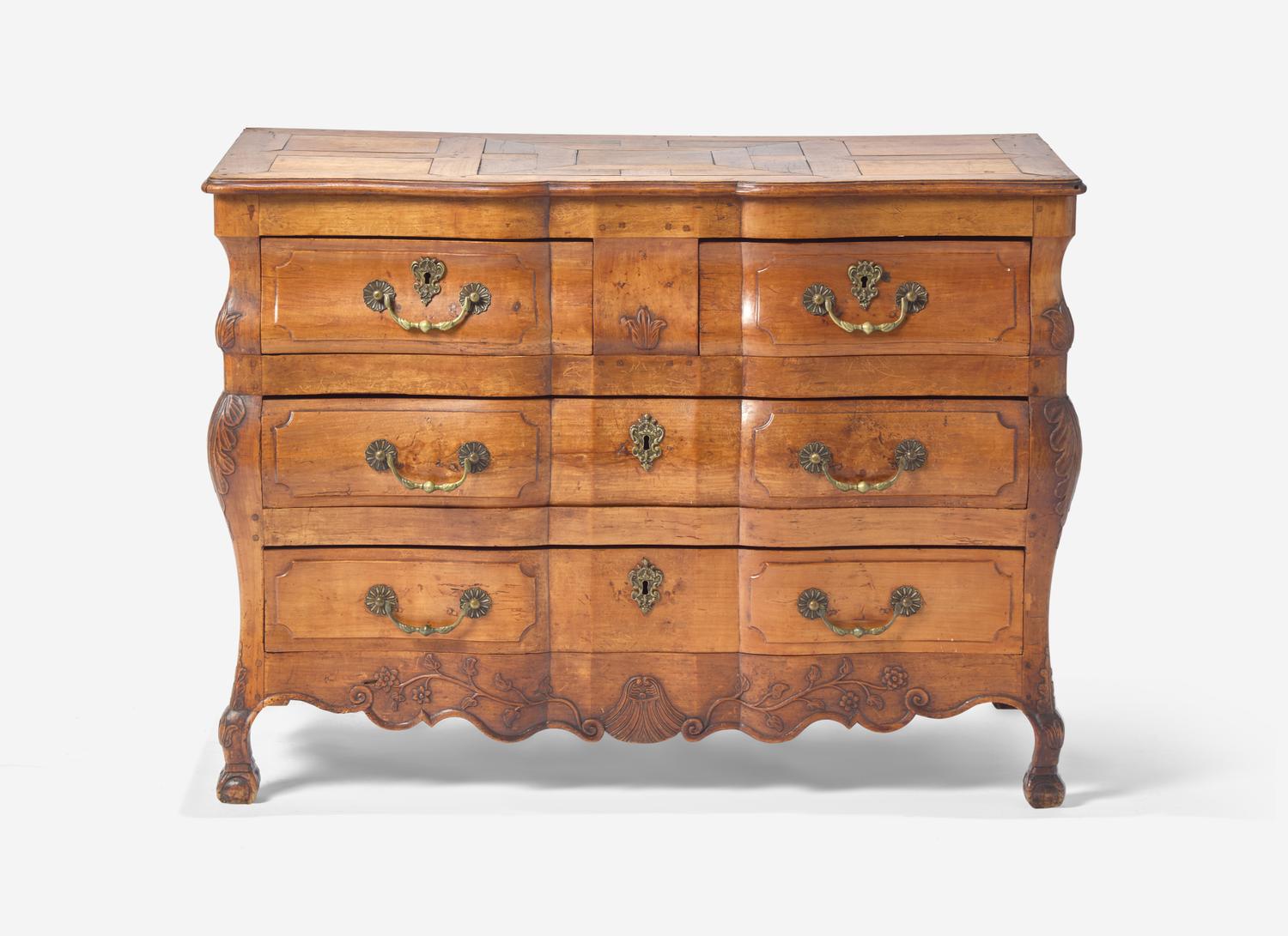 A Louis XV Provincial Carved Fruitwood Serpentine and Paneled-Top Bombé Commode