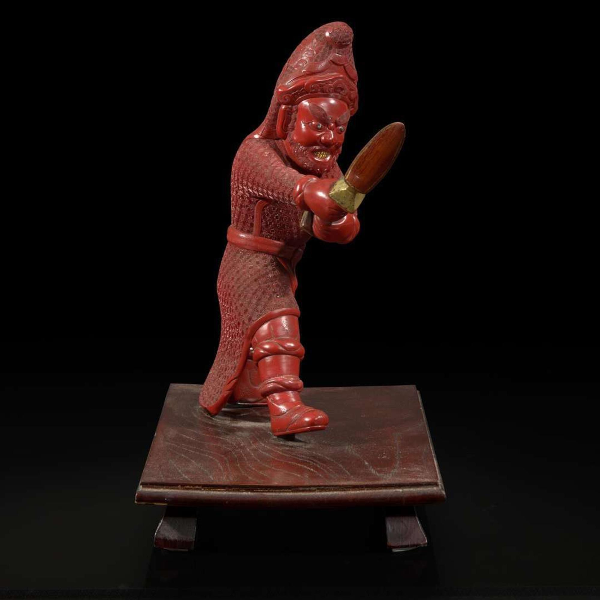 An unusual and finely-carved cinnabar lacquer figure of a warrior 朱漆武士像