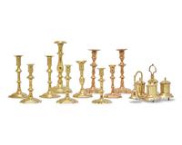 A Group of Ten Brass Candlesticks and a Brass Standish