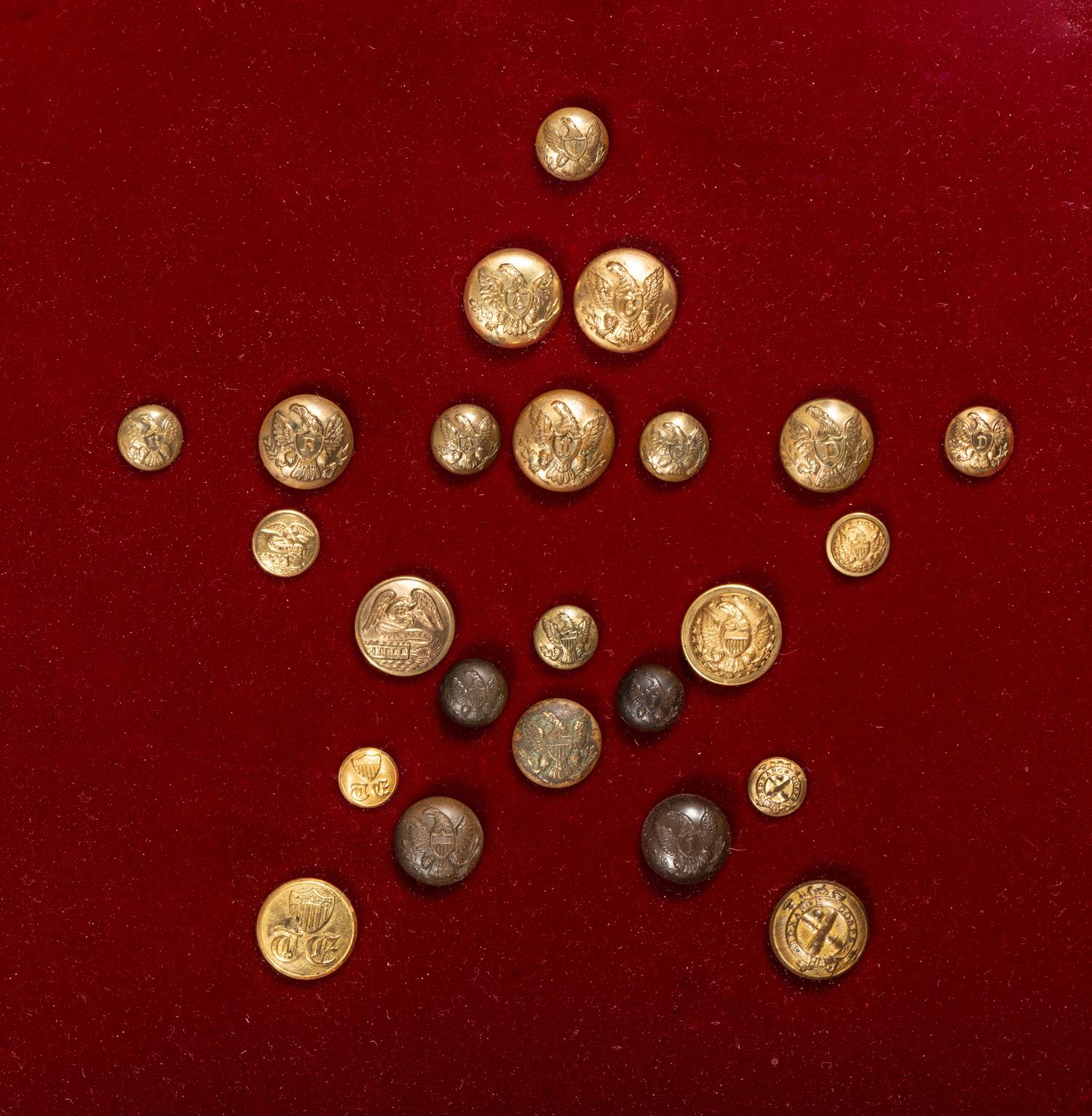 A collection of 24 Civil War buttons representing every branch of the Union Army displayed in decorative frame.