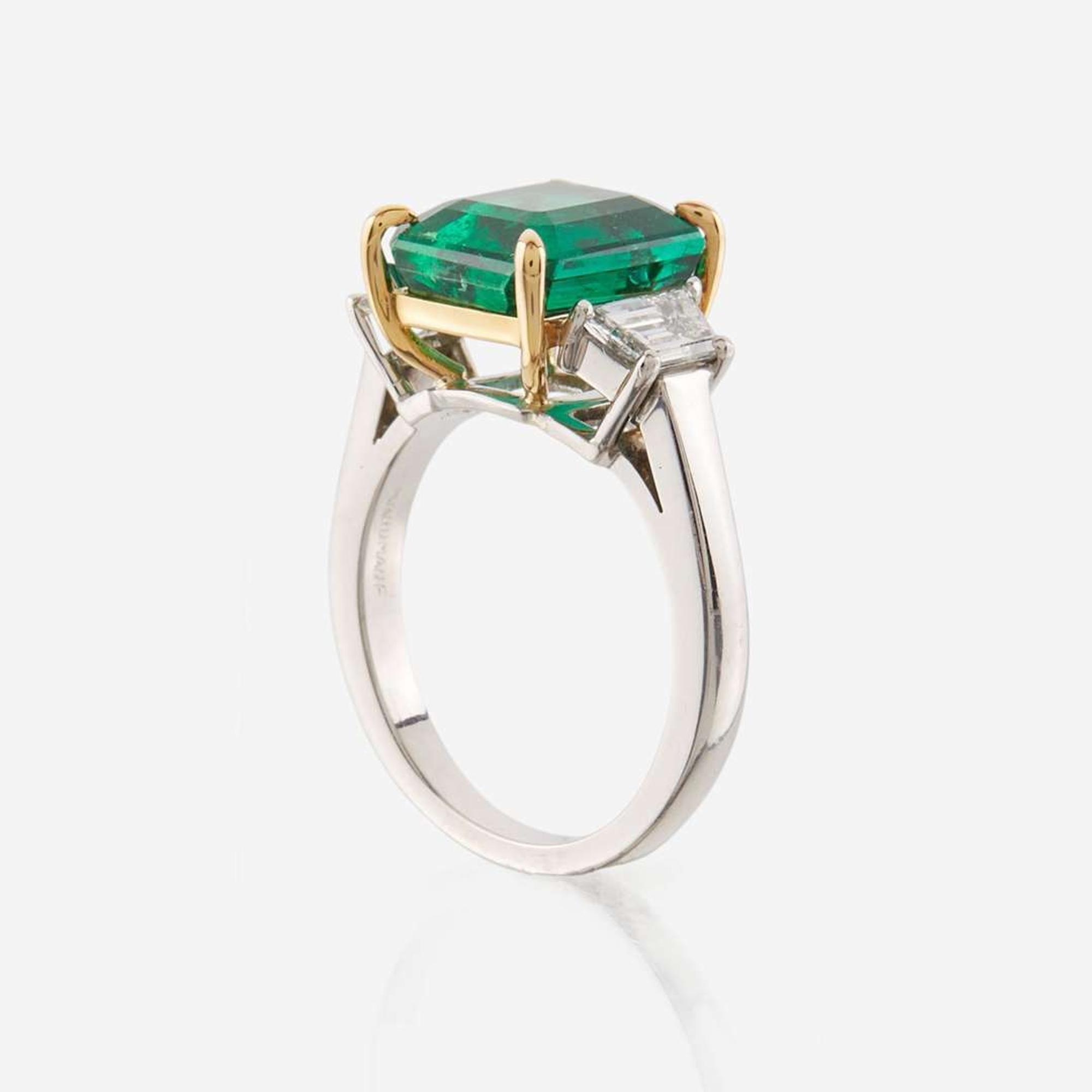 An emerald, diamond, and platinum ring