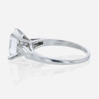 An emerald-cut diamond accented solitaire ring